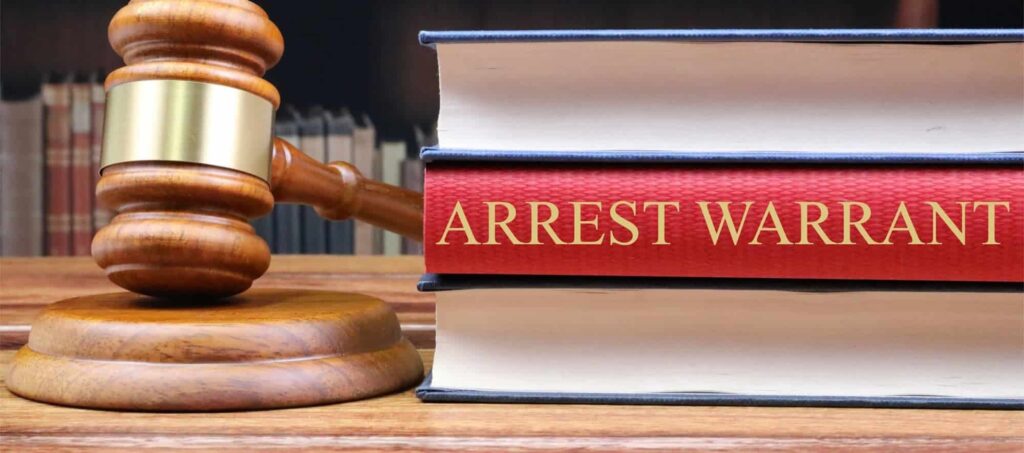 A judge 's gavel and books on arrest warrants.